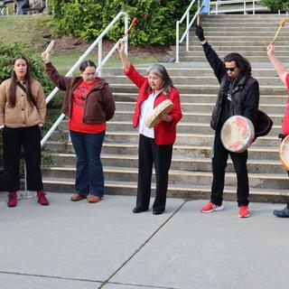 Women in red shirts with drums. 