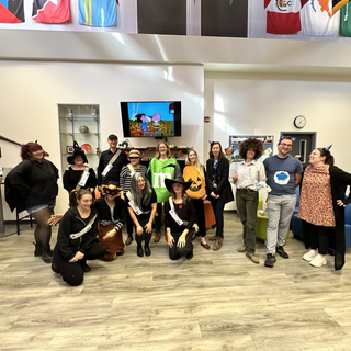 People dressed in a variety of halloween costumes in an office