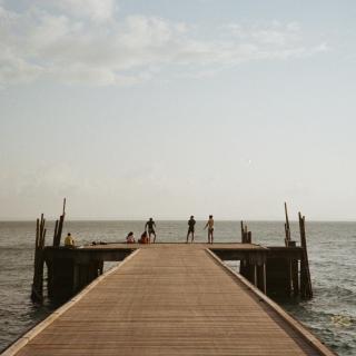 A dock with people on it, ocean behind