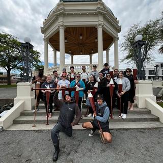 a group holding paddles poses for a photo