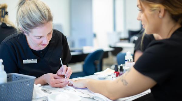 A student practices nail work on another student in the aesthetics and spa therapy classroom at VIU.