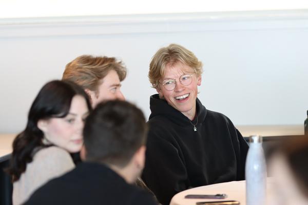 Group of students interacts while sitting at a table