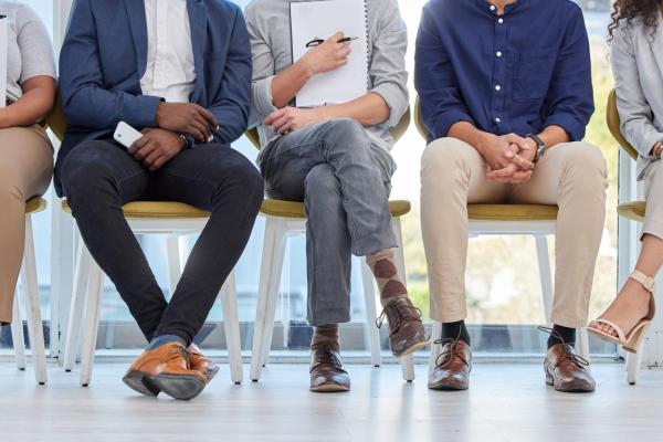 closeup of students' legs dressed in business attire sitting on chairs