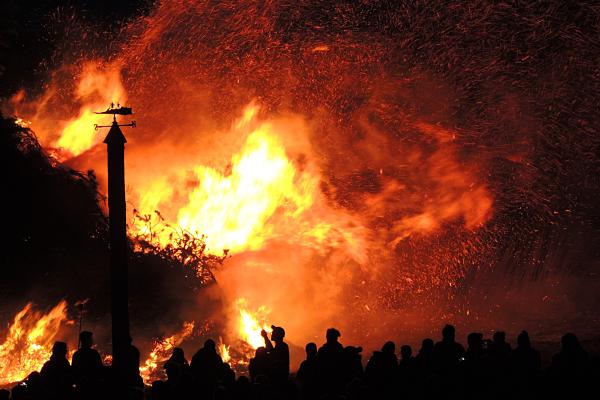 Wildfire with silhouettes of people looking on