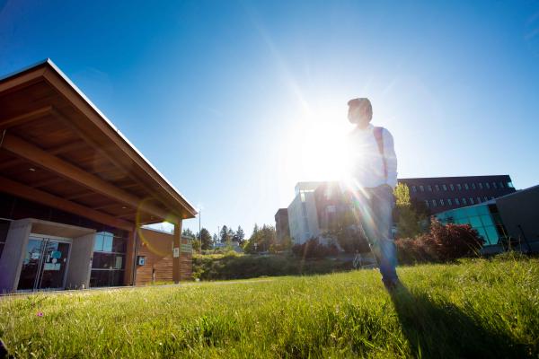 Student standing with the sun behind him