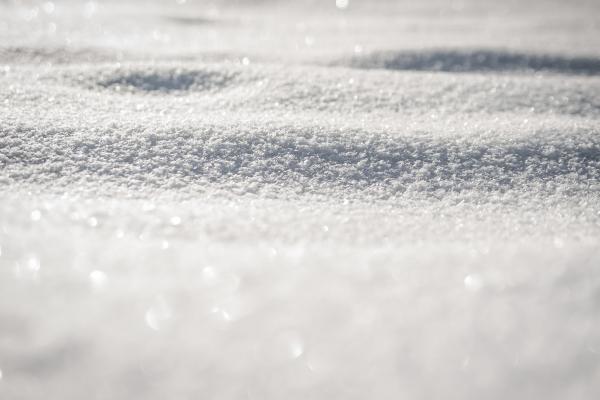 A closeup of snow with the sun shining on it.