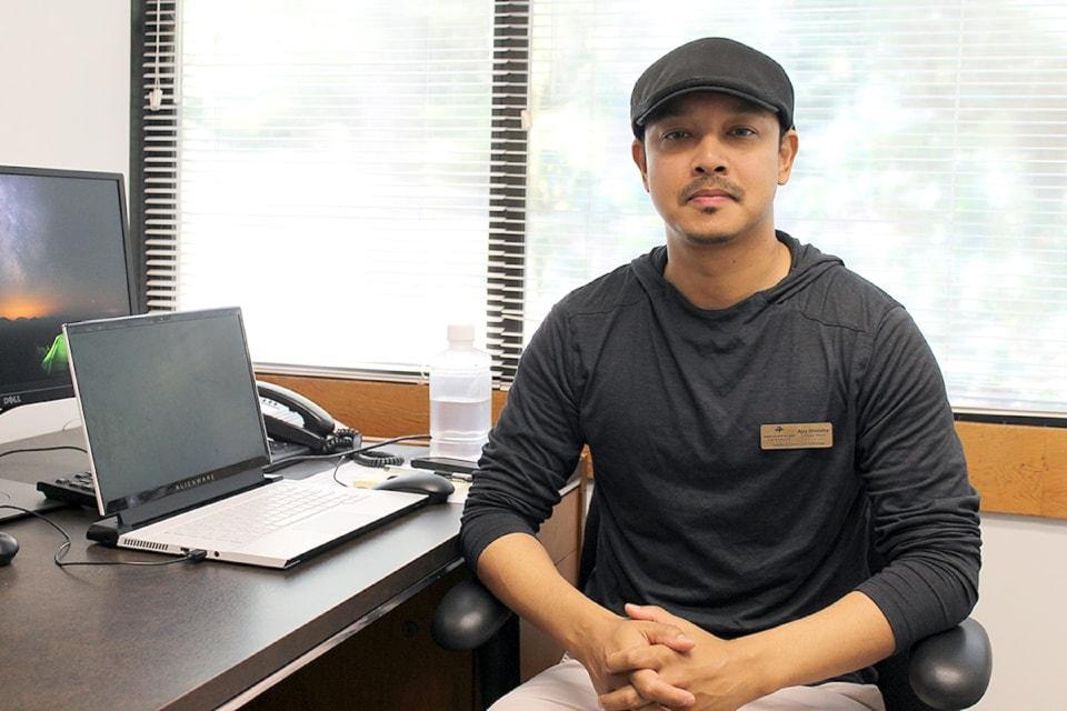 AJ sits at his desk