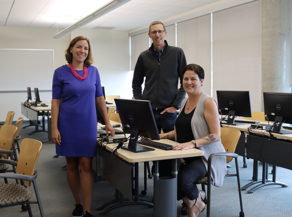 From left to right: Tracy Vandermolen, Darrell Harvey and Anwen Burk in a computer lab and smiling at the camera