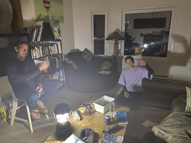 A dark room with two people by lantern light