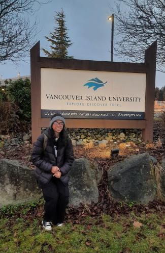 Becky in front of the VIU sign at Fifth and Wakesiah streets