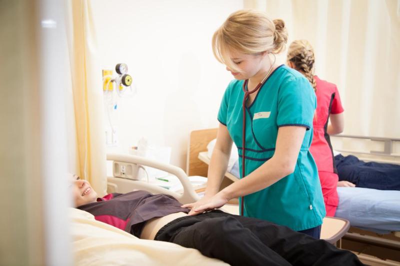 Bachelor of Science in Nursing students practice on dummies in the lab