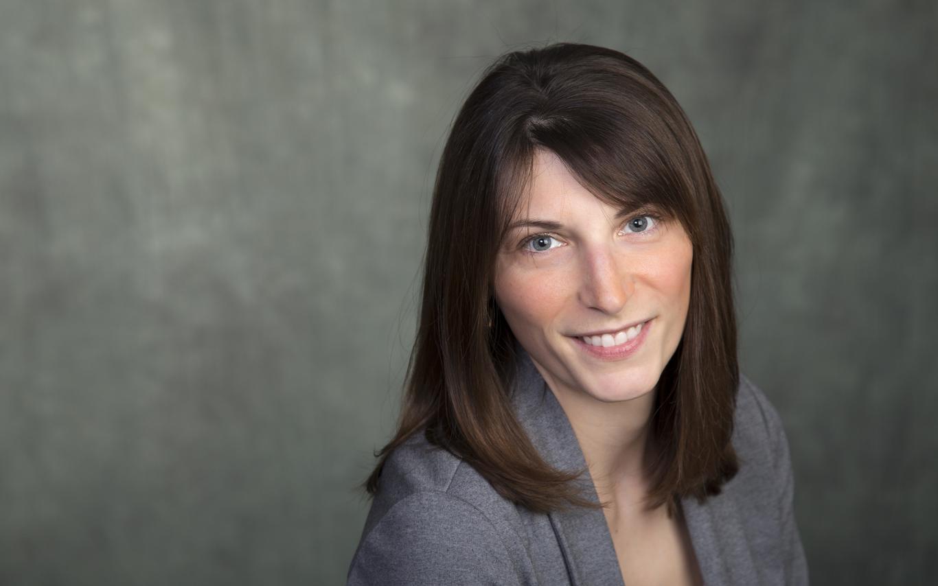 Headshot of Dr. Lindsay McCunn, wearing a grey blazer and smiling.